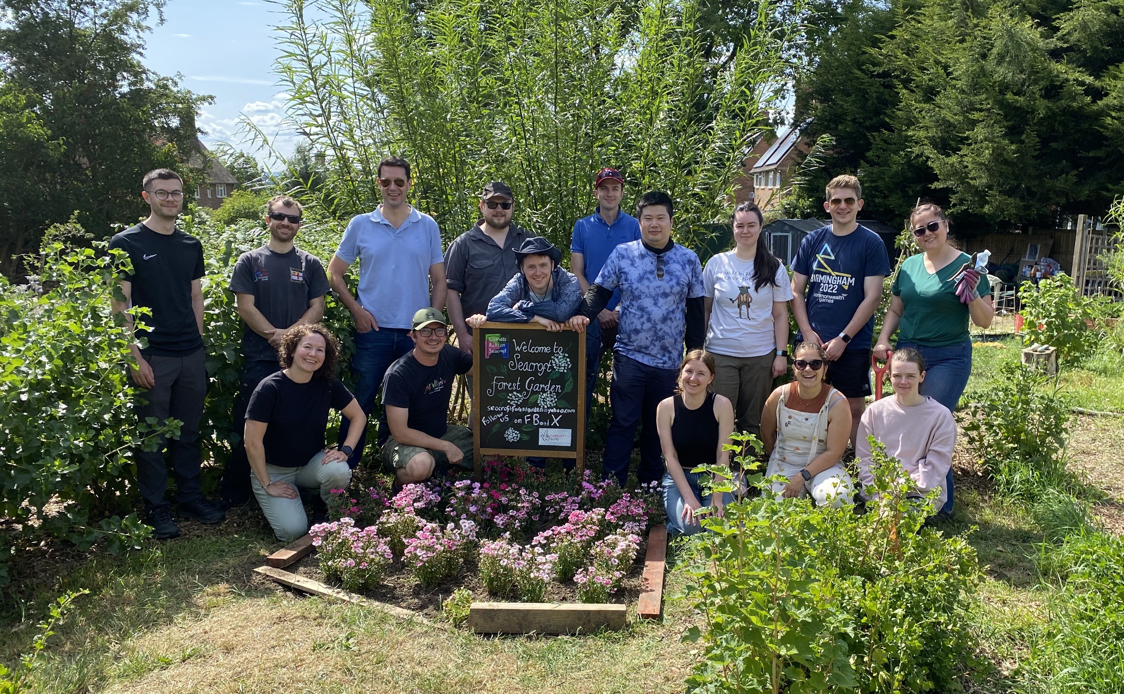Picture of the NHSE Data Science and Applied AI team, with a flower bed